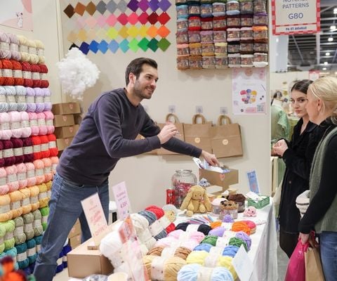 Participants découvrant des activités de loisirs créatifs sur un stand de salon