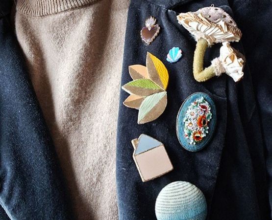 Broches artisanales colorées portées sur un vêtement