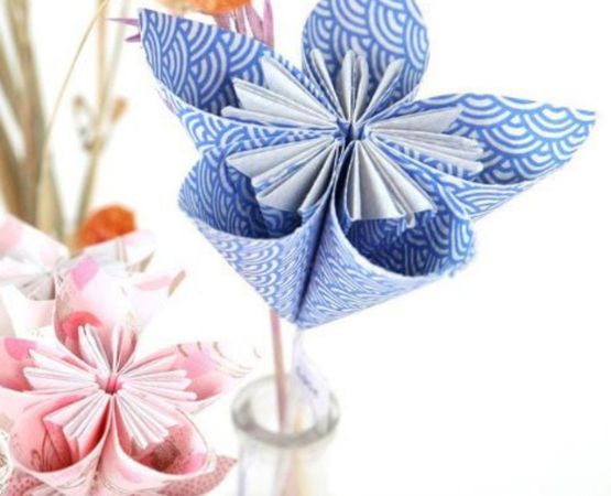 Fleurs en origami en papier imprimé bleu et rose, décorant un vase.