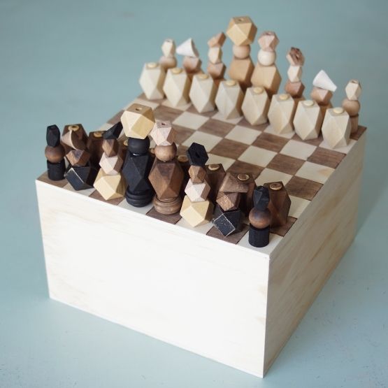Wooden chess set with geometric pieces on a square board, seen from above.