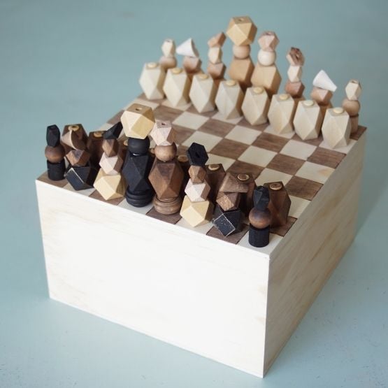 Jeu d’échecs en bois avec pièces géométriques sur un plateau carré, vu de dessus.
