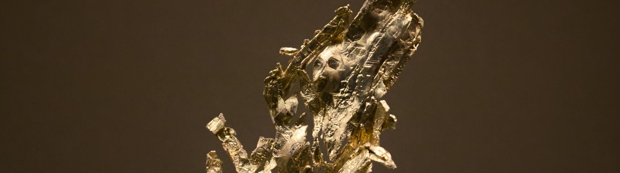 Fragment de matière dorée à l’aspect brut et texturé, évoquant une recherche artistique autour de l’or.