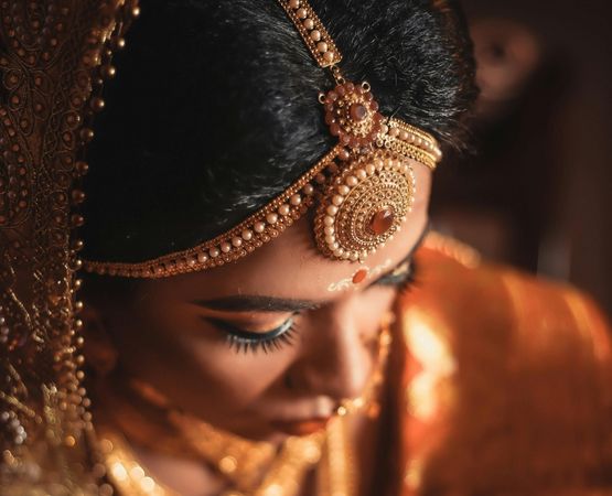 Portrait d’une femme portant des bijoux traditionnels dorés, inspirés de l’artisanat oriental.