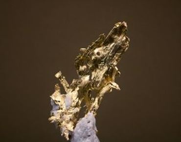 Fragment de matière dorée à l’aspect brut et texturé, évoquant une recherche artistique autour de l’or.