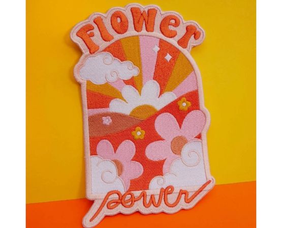 Patch brodé coloré « Flower power » avec fleurs rétro et soleil stylisé sur fond jaune.
