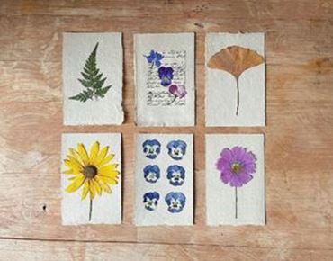 Cartes artisanales décorées avec des fleurs et feuilles pressées.