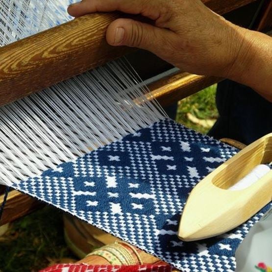 Conseils de tissage avec outils et fils colorés sur une table en bois.