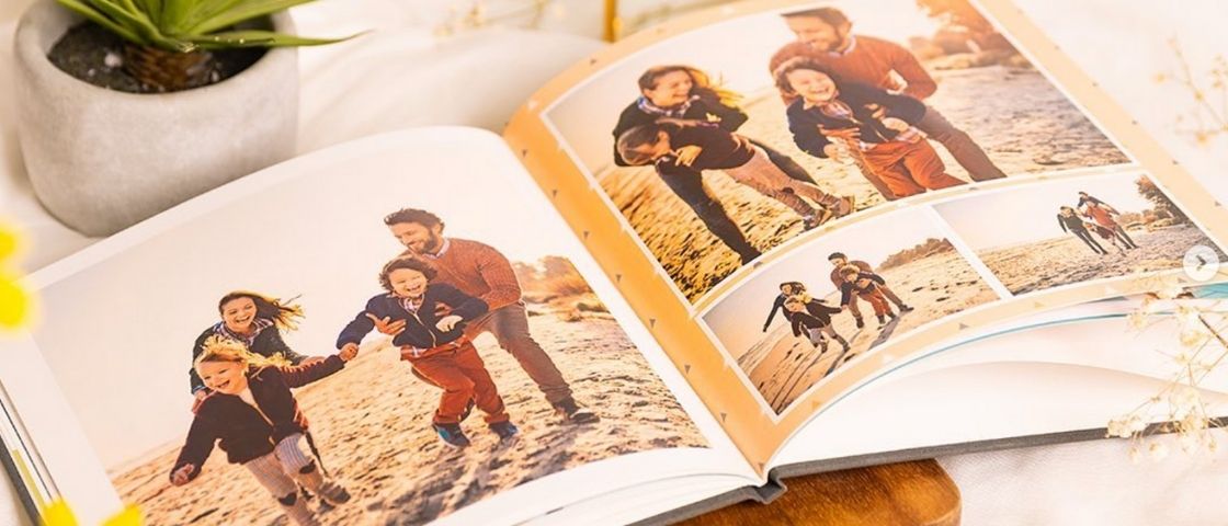 Album photo ouvert avec des photos d'une famille courant sur la plage.