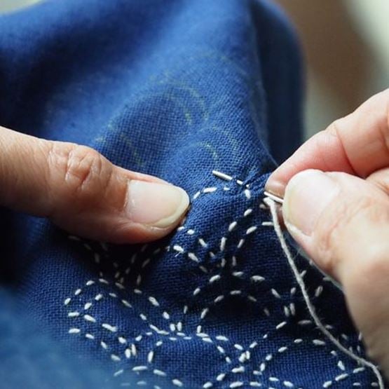 Coussin à aiguilles en tissu avec diverses aiguilles piquées