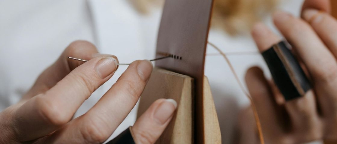 Couture du cuir à la main avec aiguille et fil en gros plan.