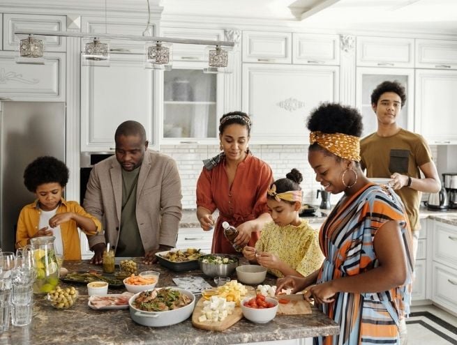 Famille réunie dans une cuisine en train de préparer un repas ensemble.