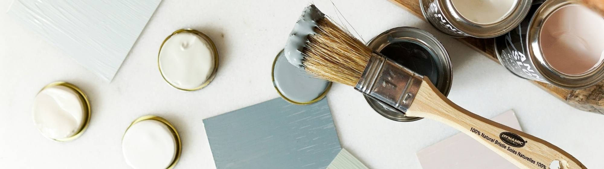 Paint shades and brushes laid out on a table for a DIY decoration project