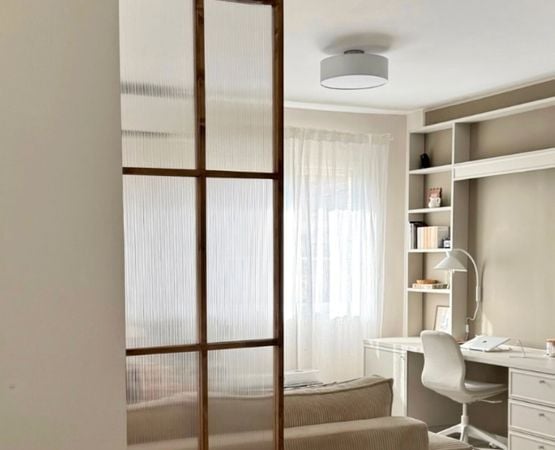 Fausse verrière en bois séparant un espace bureau dans une chambre lumineuse