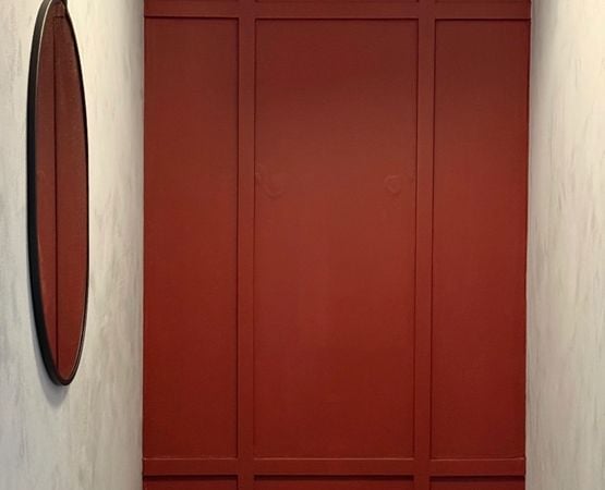Mur terracotta avec moulures décoratives dans une ambiance rétro minimaliste