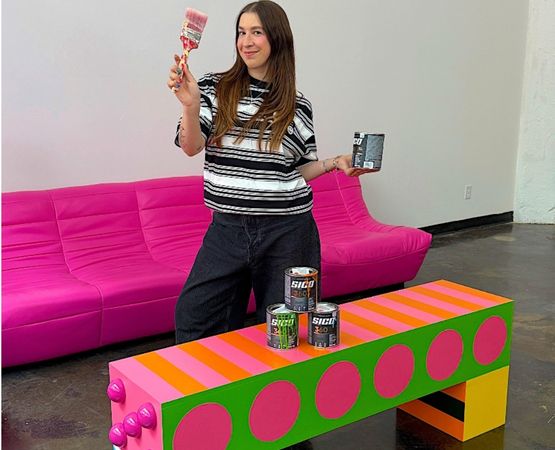 Designer presenting a colourful coffee table customised with DIY paint