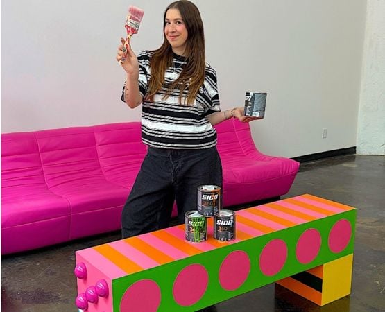 Créatrice présentant une table basse colorée customisée avec de la peinture DIY