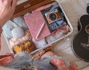 Valise ouverte avec accessoires de voyage et appareil photo