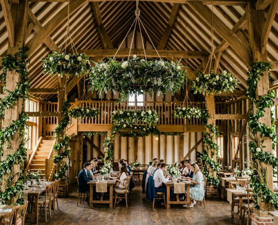 decorating a country wedding hall with wood garlands and friendly reception tables