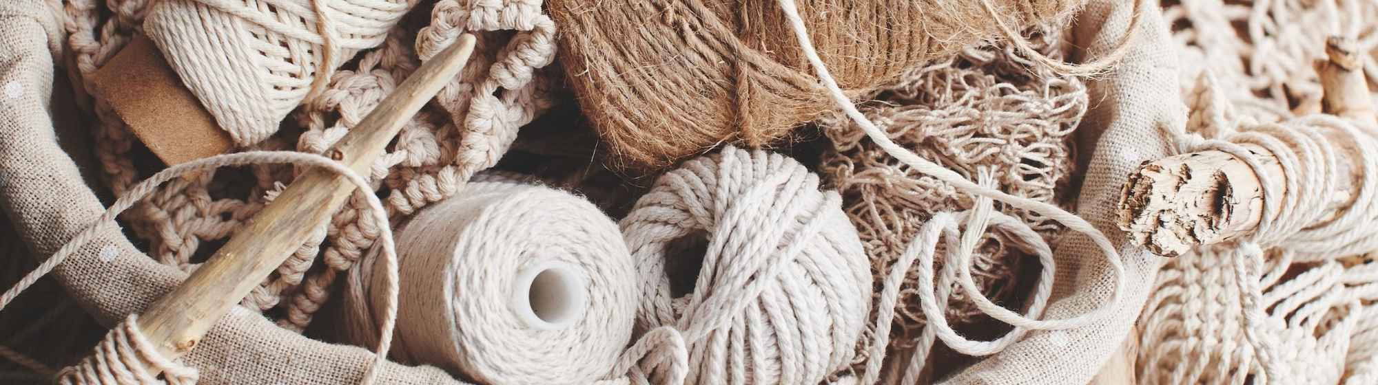 Panier avec pelotes de corde et matériaux pour macramé.