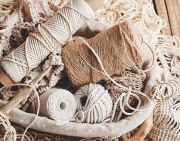 Panier avec pelotes de corde et matériaux pour macramé.