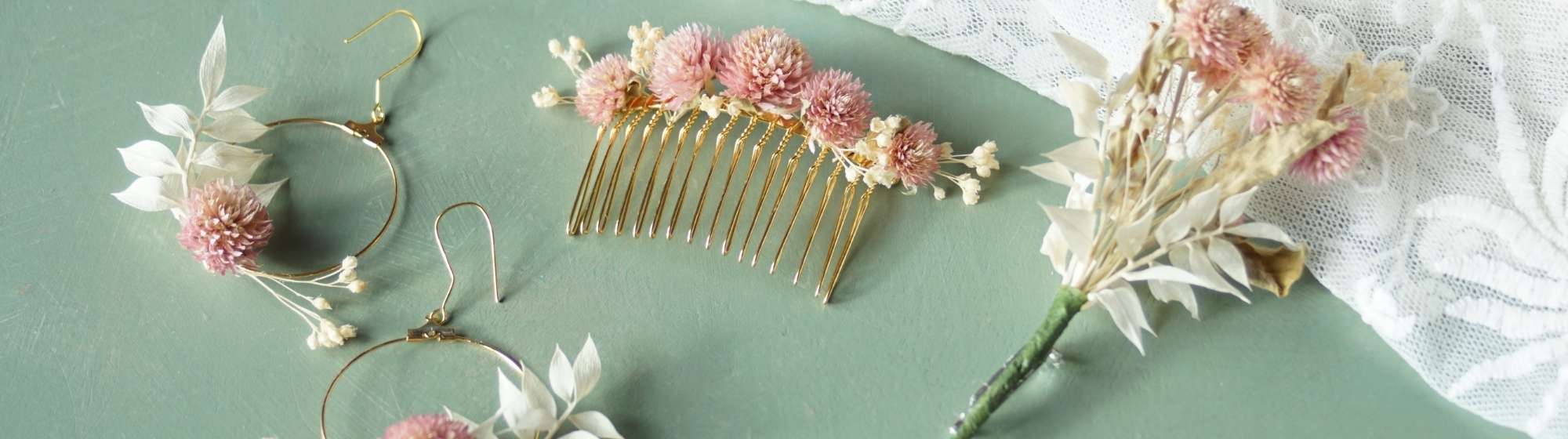 Set of dried flower jewellery and accessories, including earrings, comb and buttonhole, on a green background.