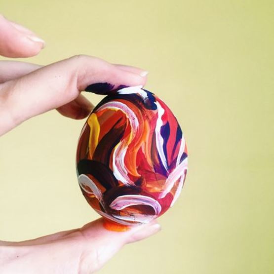 Hand-painted Easter egg with red, white and yellow motifs.