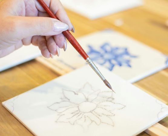 Peinture décorative sur carrelage avec motif floral réalisée au pinceau.