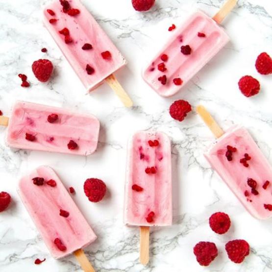 Pink water ice with raspberry pieces, set against a marbled background.