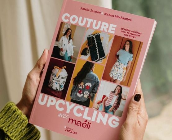 The book *Upcycling Sewing*, held in one hand