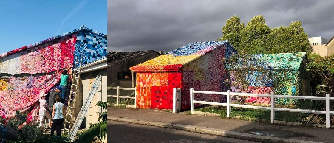 Houses covered with a colourful knitted textile installation, an outdoor artistic work