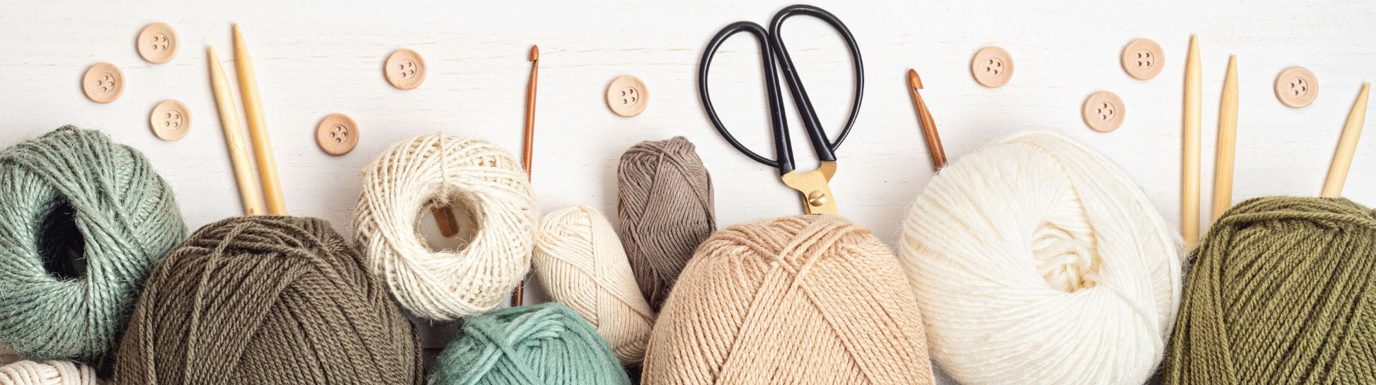 Pelotes de laine, boutons de couture et aiguilles à tricoter