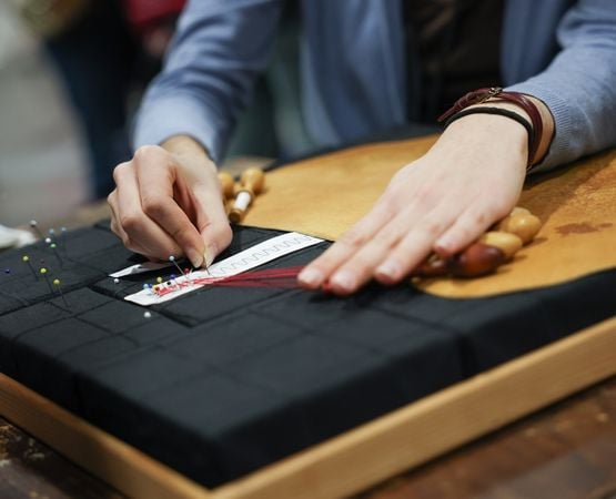 Atelier de tissage avec démonstration sur métier à tisser devant des visiteurs.