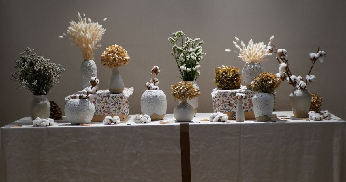 Mise en scène décoration de Noël avec des fleurs séchées dans des vases sur une table 