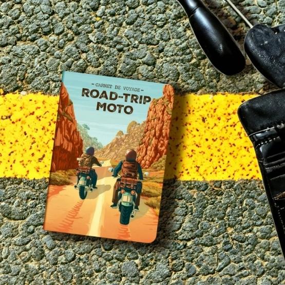 Road-Trip Moto" travel diary on a road with yellow markings.