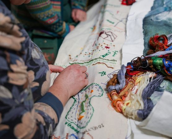 Artiste présentant une création textile colorée lors d'un événement créatif