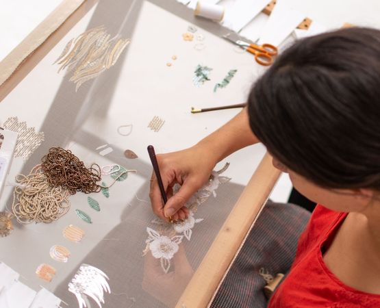 Créatrice portant un vêtement artisanal réalisé avec des techniques textiles et des gestes rares