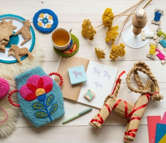 Creative table with punch needle, horse-shaped cakes and straw objects.
