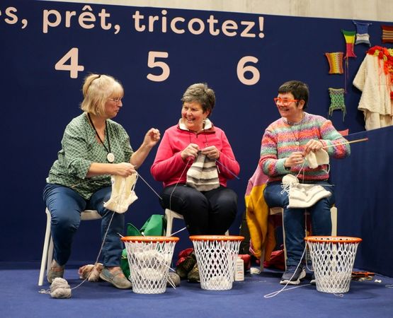 Affiche de l’événement Speed Knitting du salon Créations & Savoir-Faire 2025, avec deux participantes tricotant en duel.