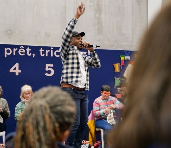 The host of the Speed Knitting competition on stage, encouraging the participants during the competition.