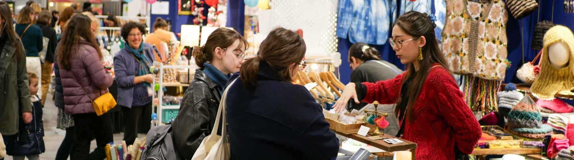 A creative fair aisle with visitors discovering the craft stands.
