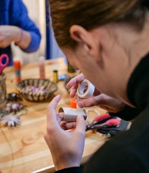 Young woman handling a roll of masking tape during a creative workshop.