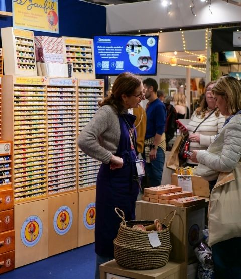 Colourful embroidery thread stand with a sales assistant talking to a customer.
