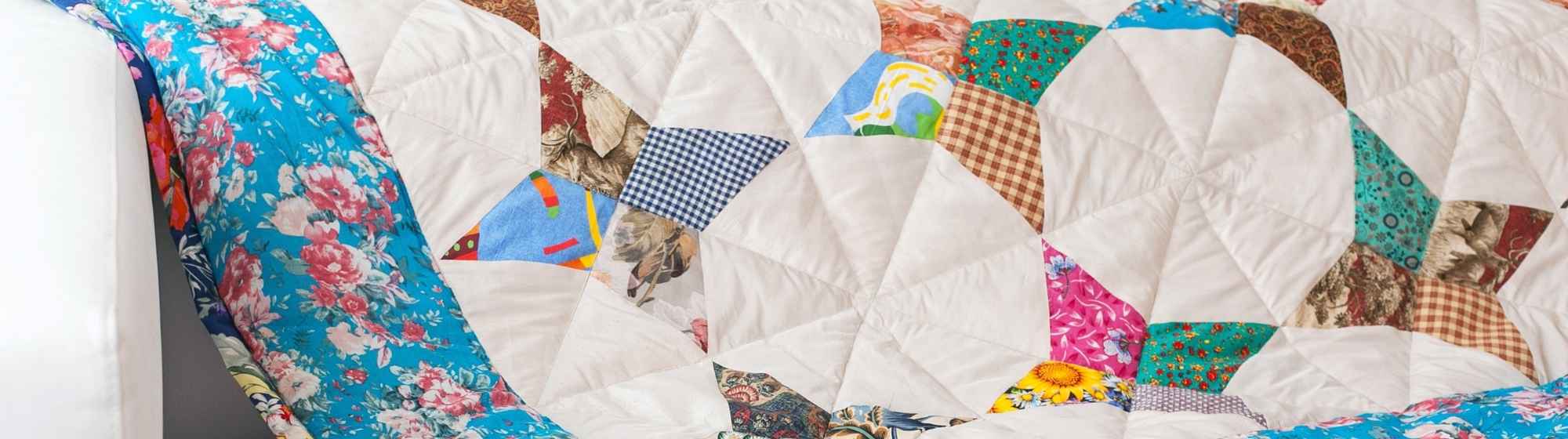 Colourful patchwork blanket on a white sofa.