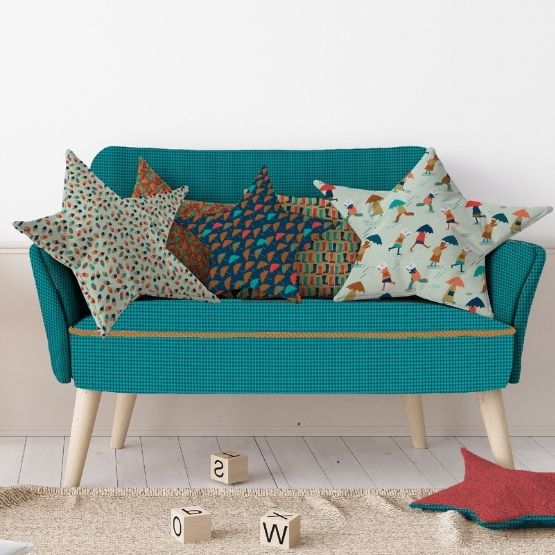 Small blue sofa with colourful star-shaped cushions.