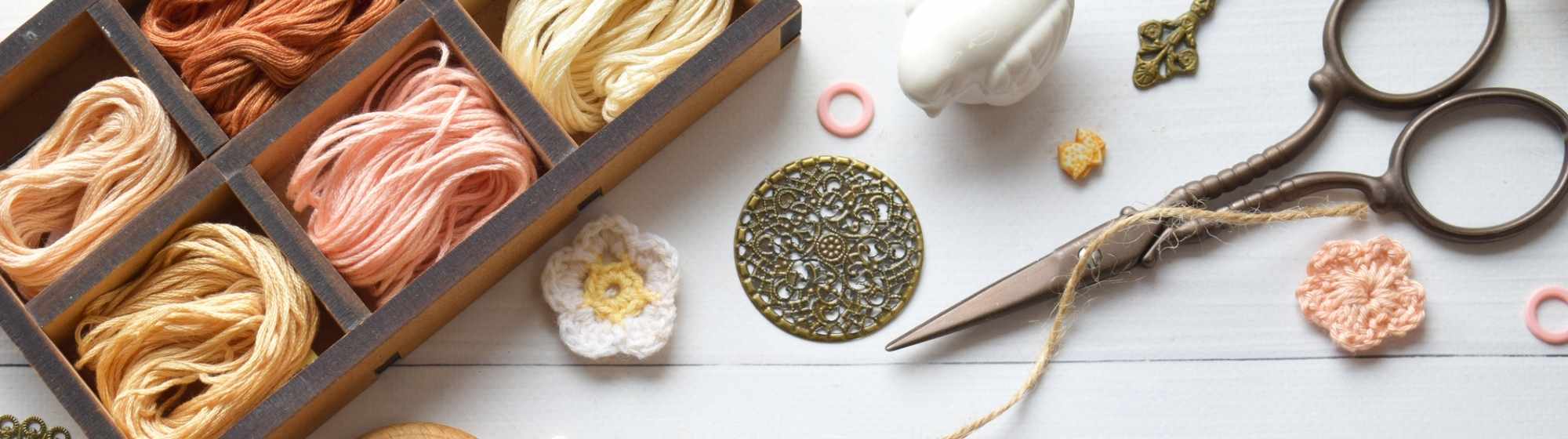 Atelier créatif avec divers fils, anneaux et ciseaux disposés sur une table.