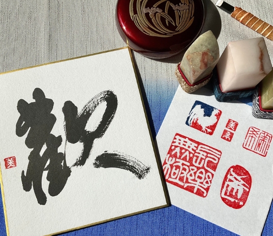 Calligraphie japonaise noire sur papier blanc accompagnée de tampons traditionnels rouges et de sceaux en pierre