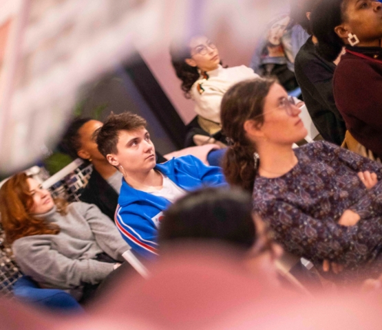 Group of people sitting attentively during an indoor training session or workshop