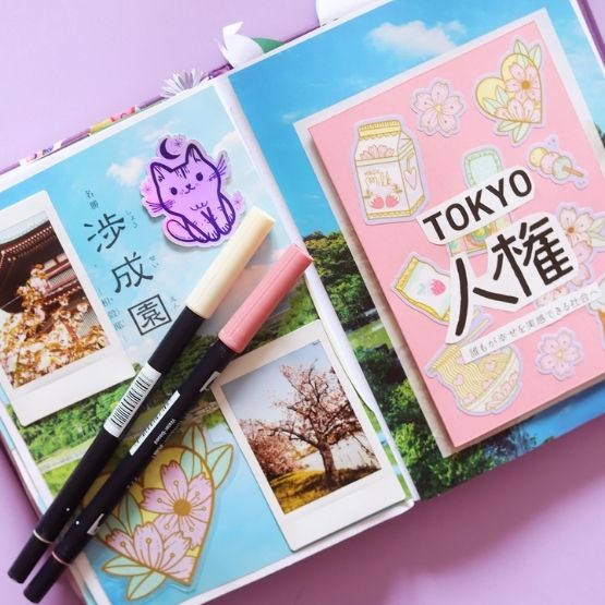 Creative travel diary about Japan with photos, drawings and cherry blossom stickers.