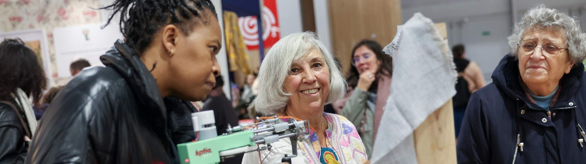 Participantes réalisant une activité de bricolage créatif avec un pistolet à colle lors d’un salon DIY