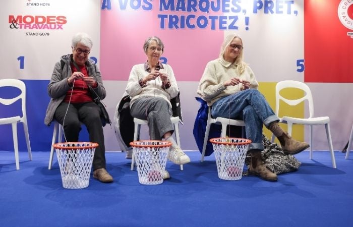 Participantes prenant part à un atelier de tricot collectif lors d’un événement créatif